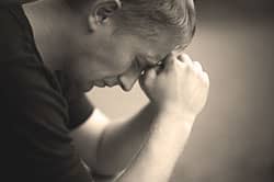 man praying at faith-based drug treatment center