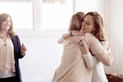 Two women hugging in a rehab program