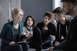 therapist talks to group of young adults